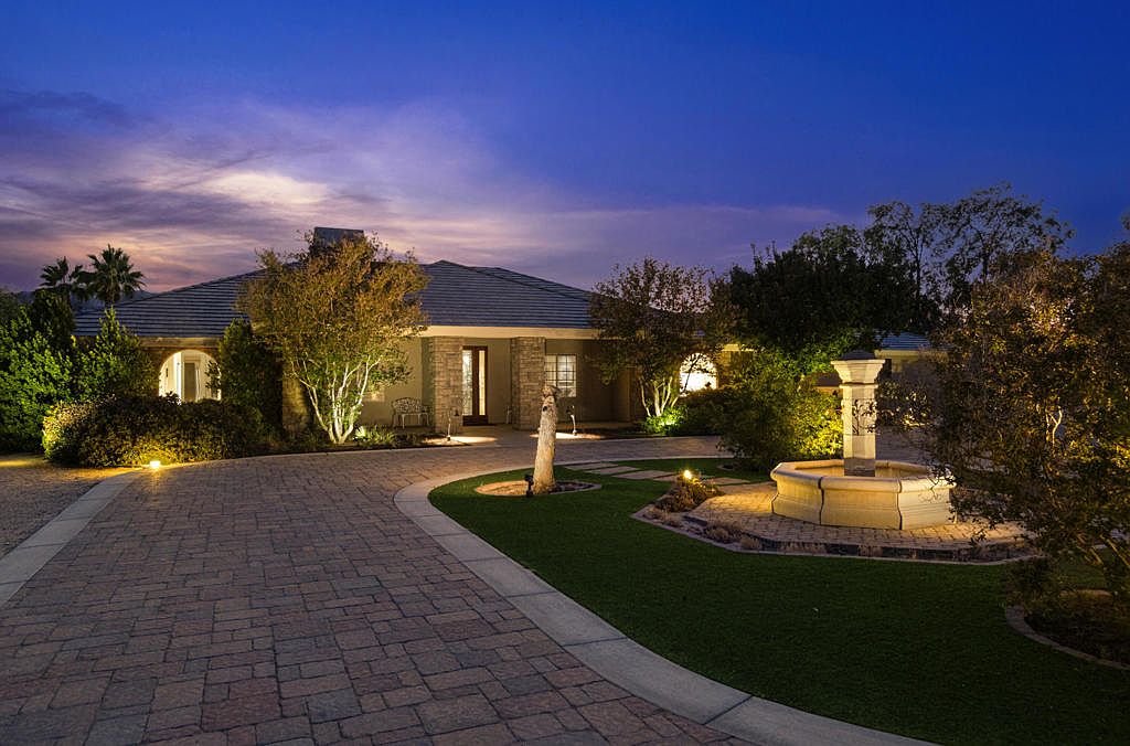 The Via Josefina estate at twilight — illuminated entry, central fountain, and desert palms