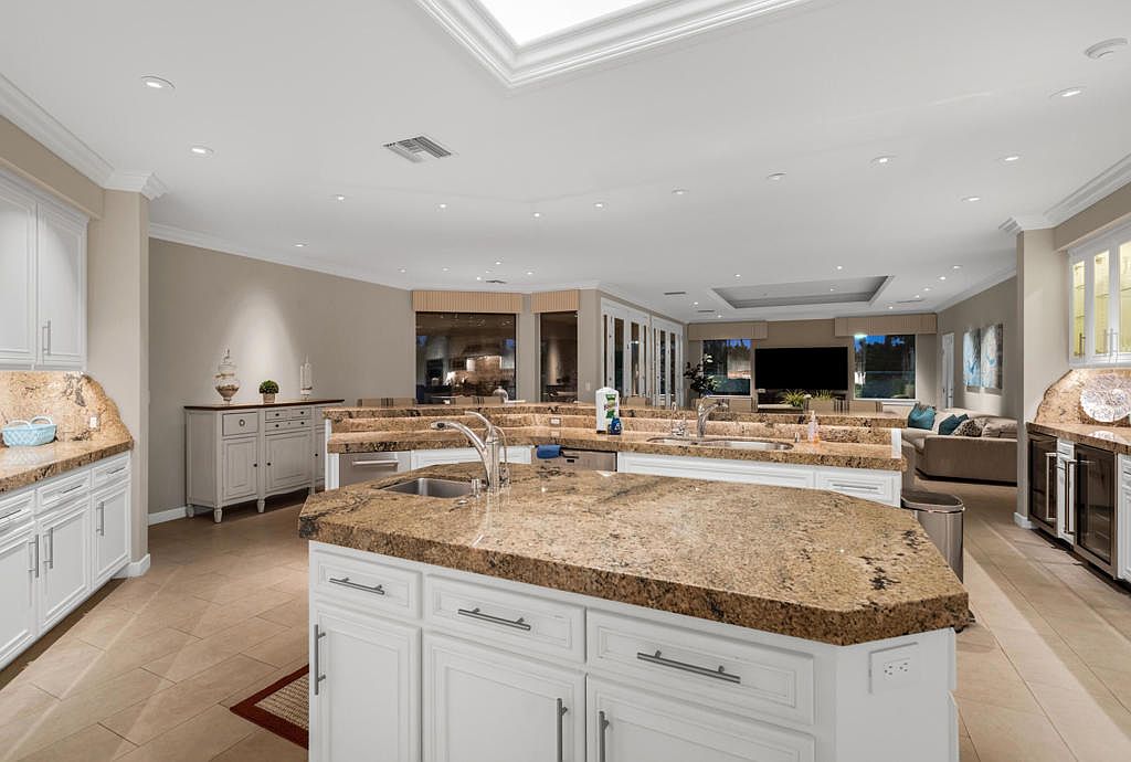 The kitchen at another angle — granite, stainless, prep stations