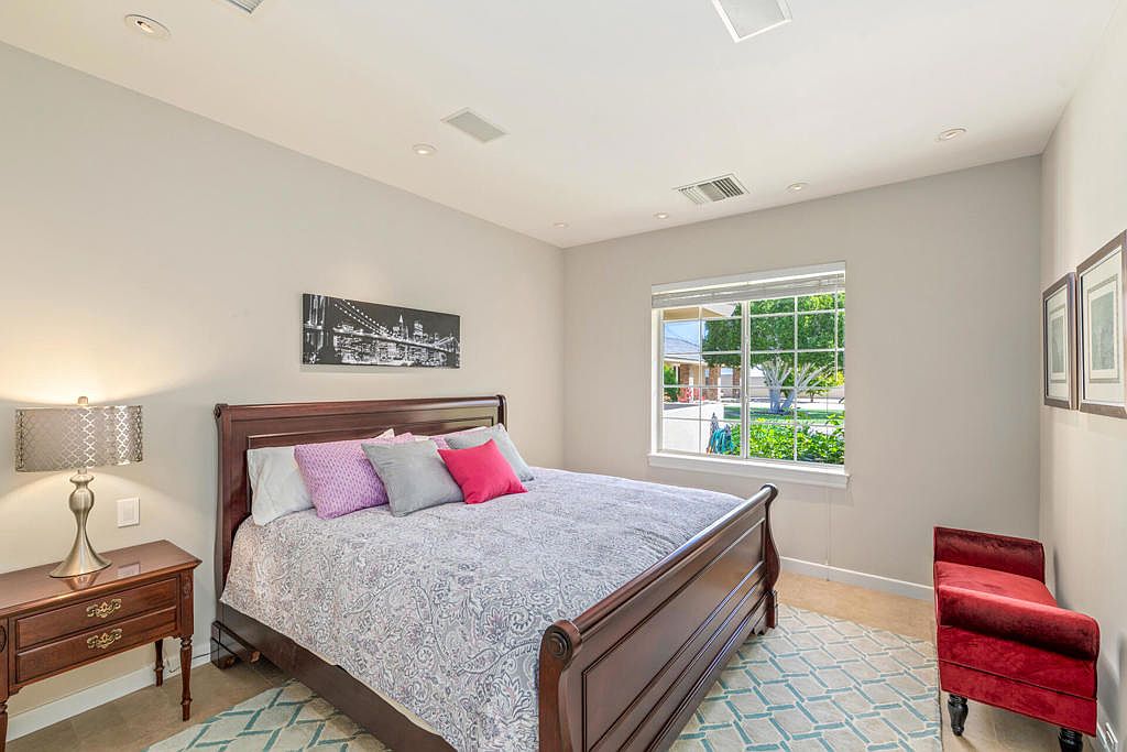 A private bedroom with a dark-wood sleigh bed and natural daylight